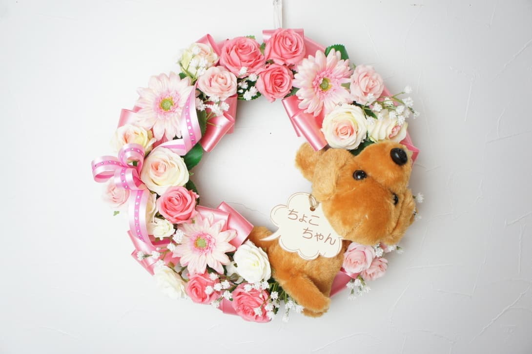 ワンちゃんのリース　高級造花専門店アンクラフトは１級フラワー装飾技能士がアーティフィシャルフラワー（造花）を使用し、ご希望のアレンジメント、髪飾り、ブーケをオーダーメイドで制作致します。結婚記念日やお見舞いの花、花言葉に合わせたお花の贈り物や開店花、待合室用、応接用花、個性的な髪飾りや派手な花、大人可愛い、おしゃれなバラなどどんなオーダーでもお気軽にお問い合わせください。大阪、兵庫県、関西からアクセスが簡単。