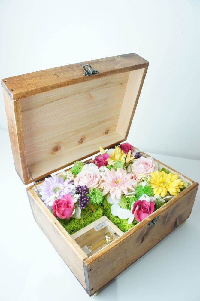 オルゴールBOXアレンジ　高級造花専門店アンクラフトは１級フラワー装飾技能士がアーティフィシャルフラワー（造花）を使用し、ご希望のアレンジメント、髪飾り、ブーケをオーダーメイドで制作致します。結婚記念日やお見舞いの花、花言葉に合わせたお花の贈り物や開店花、待合室用、応接用花、個性的な髪飾りや派手な花、大人可愛い、おしゃれなバラなどどんなオーダーでもお気軽にお問い合わせください。大阪、兵庫県、関西からアクセスが簡単。