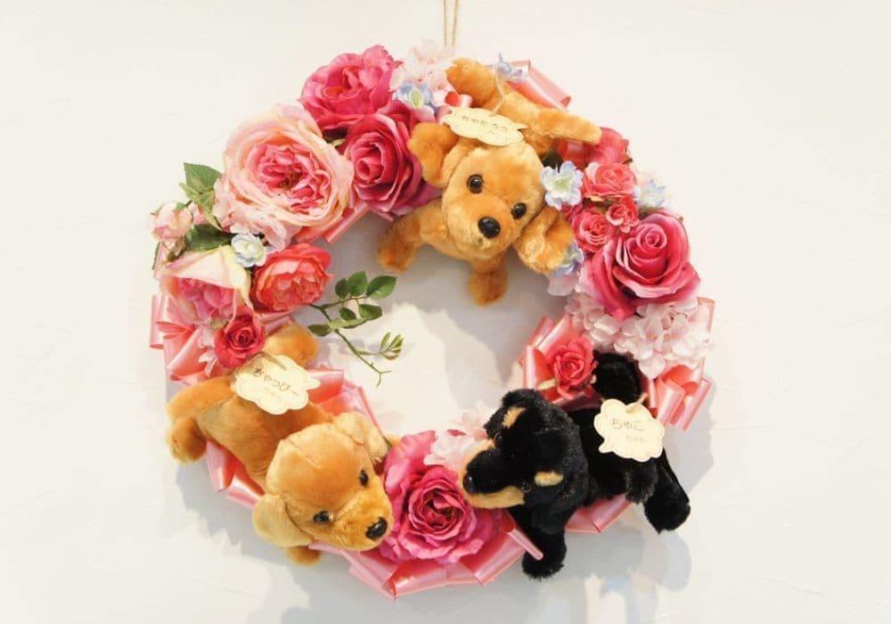 わんこのリース　高級造花専門店アンクラフトは１級フラワー装飾技能士がアーティフィシャルフラワー（造花）を使用し、ご希望のアレンジメント、髪飾り、ブーケをオーダーメイドで制作致します。結婚記念日やお見舞いの花、花言葉に合わせたお花の贈り物や開店花、待合室用、応接用花、個性的な髪飾りや派手な花、大人可愛い、おしゃれなバラなどどんなオーダーでもお気軽にお問い合わせください。大阪、兵庫県、関西からアクセスが簡単。