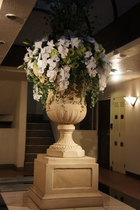 エントランス花　高級造花専門店アンクラフトは１級フラワー装飾技能士がアーティフィシャルフラワー（造花）を使用し、ご希望のアレンジメント、髪飾り、ブーケをオーダーメイドで制作致します。結婚記念日やお見舞いの花、花言葉に合わせたお花の贈り物や開店花、待合室用、応接用花、個性的な髪飾りや派手な花、大人可愛い、おしゃれなバラなどどんなオーダーでもお気軽にお問い合わせください。大阪、兵庫県、関西からアクセスが簡単。