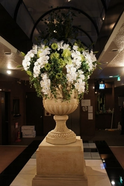 エントランス花　高級造花専門店アンクラフトは１級フラワー装飾技能士がアーティフィシャルフラワー（造花）を使用し、ご希望のアレンジメント、髪飾り、ブーケをオーダーメイドで制作致します。結婚記念日やお見舞いの花、花言葉に合わせたお花の贈り物や開店花、待合室用、応接用花、個性的な髪飾りや派手な花、大人可愛い、おしゃれなバラなどどんなオーダーでもお気軽にお問い合わせください。大阪、兵庫県、関西からアクセスが簡単。